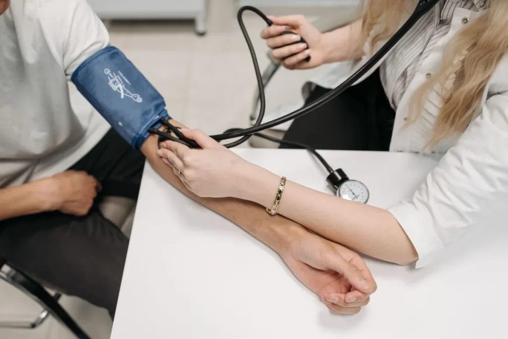 Profesional sanitario midiendo la tensión arterial a un paciente con esfigmomanómetro