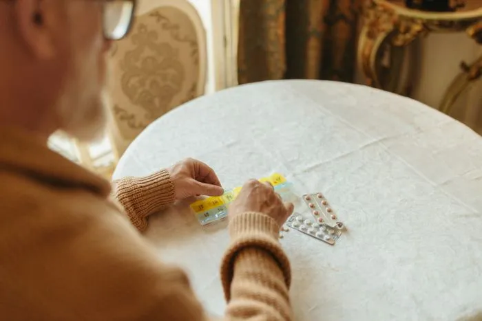 Manos organizando pastillas sobre una mesa