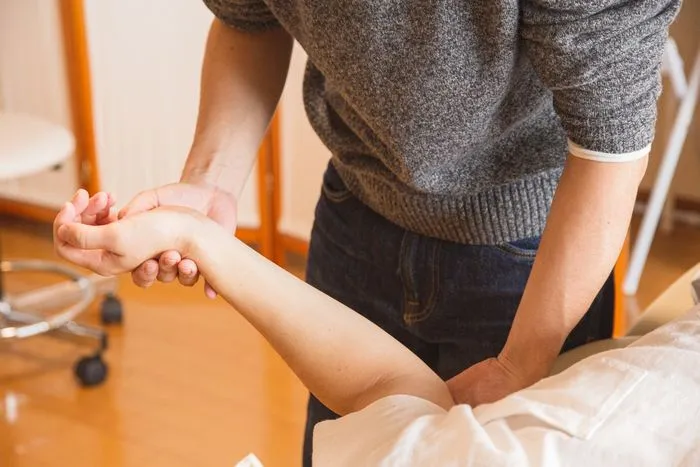 Terapeuta trabajando la mano de una paciente